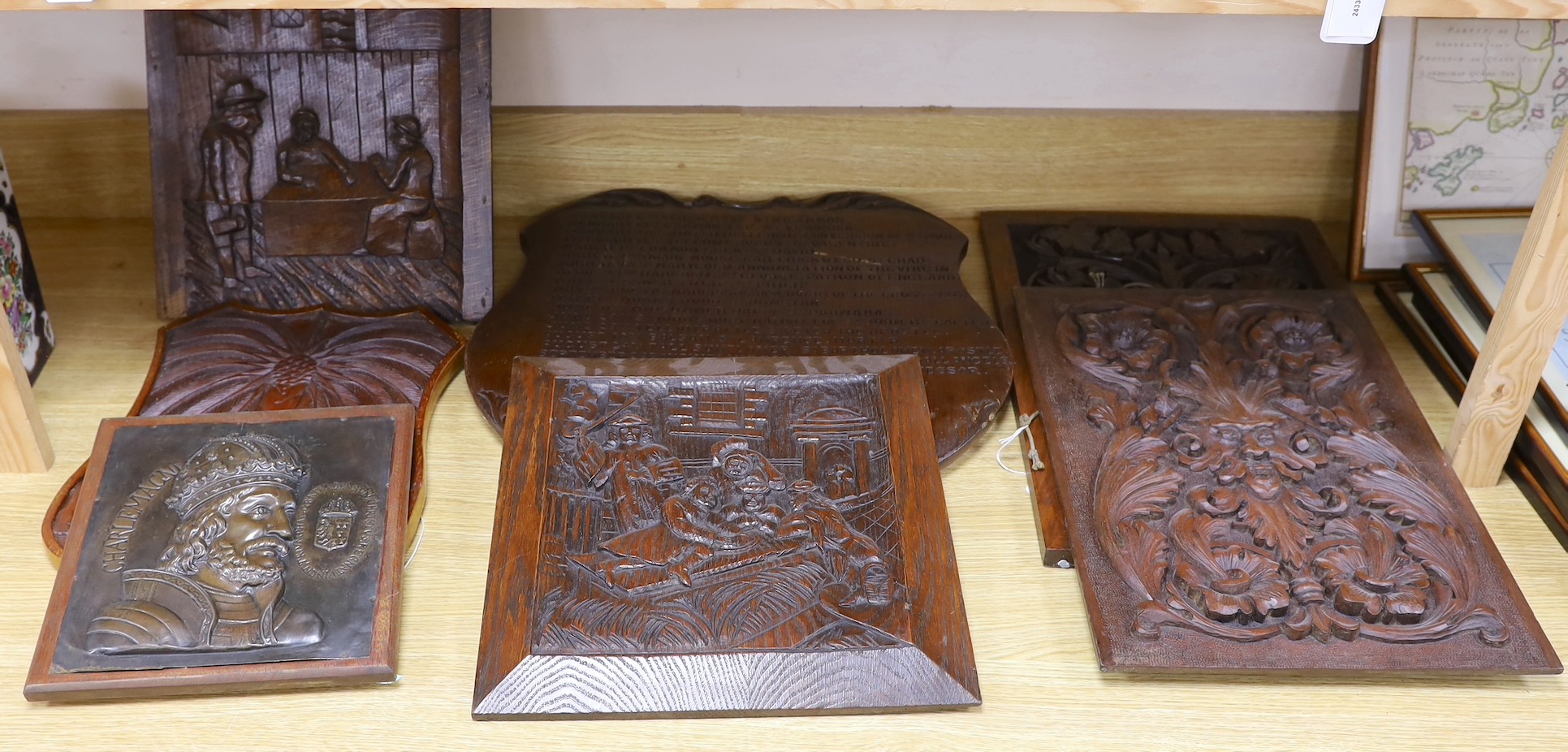 Six mixed oak carved panels and a metal relief mounted panel